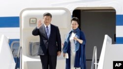 Le président chinois Xi Jinping, à gauche, et son épouse Peng Liyuan arrivent au sommet du G-20 à Hambourg, dans le nord de l'Allemagne, jeudi 6 juillet 2017. 