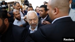 Rached Ghannouchi (C), leader of Ennahda Party, speaks to the media after a meeting, as part of a dialogue between ruling Islamists and the opposition, which aims to pave the way for the formation of a transitional government, in Tunis, Nov. 2, 2013. 