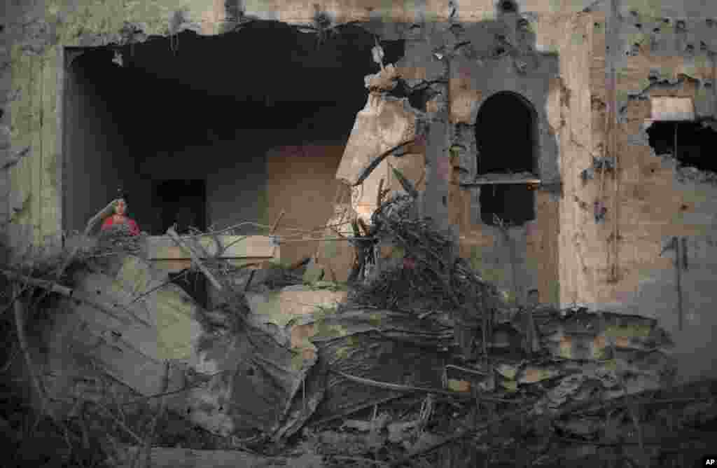 A Palestinian girl checks the damage of her family house following an overnight Israeli airstrike in Gaza City, July 8, 2014. 