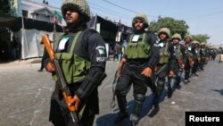 FILE - Policemen walk along a road for security measures during the religious procession ahead of Ashura in Karachi, Pakistan, Oct. 11, 2016. Karachi police killed five suspected terrorists they believe were planning an attack on the day of Ashura.