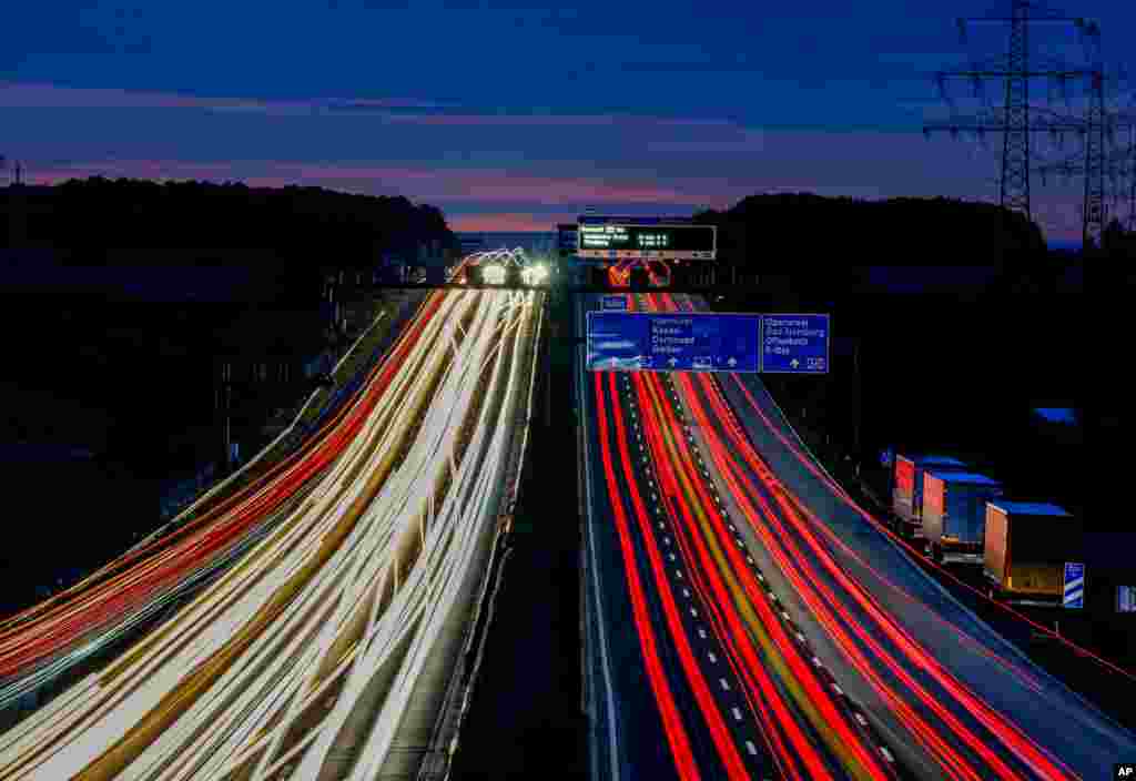A long camera exposure shows vehicles driving along a highway in Frankfurt, Germany, before sunrise.