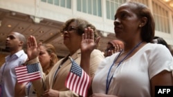 People take the oath as the US Citizenship and Immigration Services welcomes 200 new citizens from nearly 50 countries during a ceremony in honor of Independence Day at the New York Public Library, July 3, 2018, in New York.