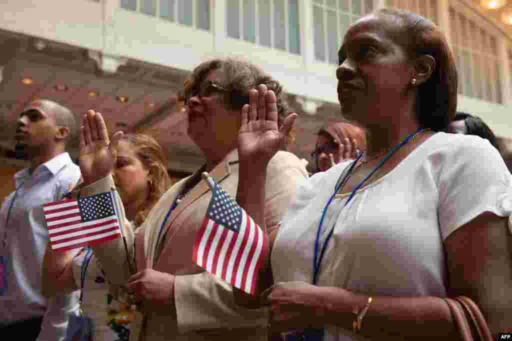 People take the oath as the US Citizenship and Immigration Services welcomes 200 new citizens from 50 countries during a ceremony in honor of Independence Day at the New York Public Library, July 3, 2018, in New York.