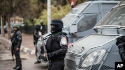 FILE - Policemen stand guard in Tahrir Square in Cairo, Egypt.