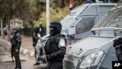 FILE - Policemen stand guard on the anniversary of the 2011 uprising in Tahrir Square in the Haram district of Cairo, Egypt, Jan. 25, 2016. 