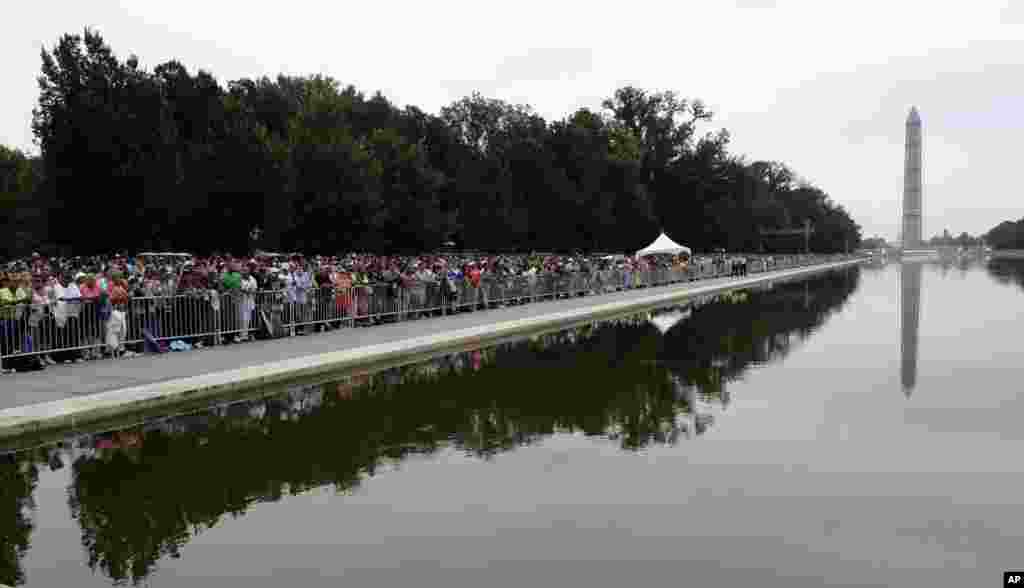 People gather around the reflecting pool near the Lincoln Memorial, Aug. 28, 2013, to listen to President Barack Obama speak during the 50th anniversary of the March on Washington. 