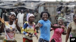 Local residents react to news of the capture of Laurent Gbagbo in the Youpougon neighborhood of Abidjan, Apr 11 2011.