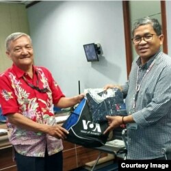 Heribertus Sunu Budiarjo (kiri) menerima cindera mata VOA dari Direktur Biro Jakarta, Agus Sunarto. (Foto: Sunu Budiarjo)
