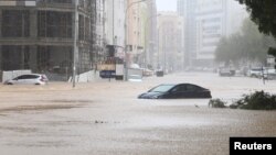 Mobil-mobil terendam air di jalanan yang dilanda banjir akibat badai Shaheen di Muscat, Oman Minggu (3/10). 
