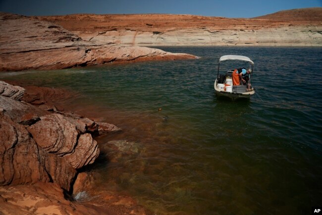 A Utah State University research team works at Lake Powell on June 7, 2022, in Page, Arizona. (AP Photo/Brittany Peterson, File)