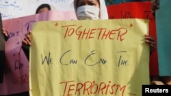 A woman holds a placard during a protest to condemn the Taliban attack on a Pakistani school, during a rally in Peshawar, Dec. 17, 2014. Maulana Fazlullah is leader of the Pakistani Taliban that claimed responsibility for the attack.