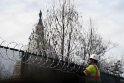 With the U.S. Capitol dome in the background, razor wire is installed to increase security ahead of the inauguration of President-elect Joe Biden and Vice President-elect Kamala Harris, in Washington, Jan. 17, 2021.