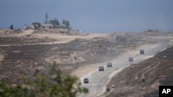 Iring-iringan mobil militer Israel meninggalkan Jalur Gaza tampak dari bagian selatan Israel, Rabu, 12 Juni 2024. (Foto: Tsafrir Abayov)