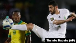 Rafik Halliche de l'Algérie, à droite, contrôle le ballon dans un duel aérien avec Sibusiso Vilakazi de l'Afrique du Sud lors de la phase finale de Coupe d’Afrique des Nations, 19 janvier 2015. 