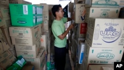 一名穆斯林志願工作人員在馬來西亞首都吉隆坡為準備運送災區的救災物品進行包裝工作。