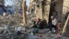 Palestinians sit amid rubble at the site of an Israeli strike on a house, amid the Israel-Hamas conflict, in Nuseirat in the central Gaza Strip, Dec. 1, 2024. 