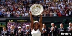 Serena Williams of the U.S.A lifts the trophy after winning her Women's Final match against Garbine Muguruza of Spain at the Wimbledon Tennis Championships in London on July 11, 2015.