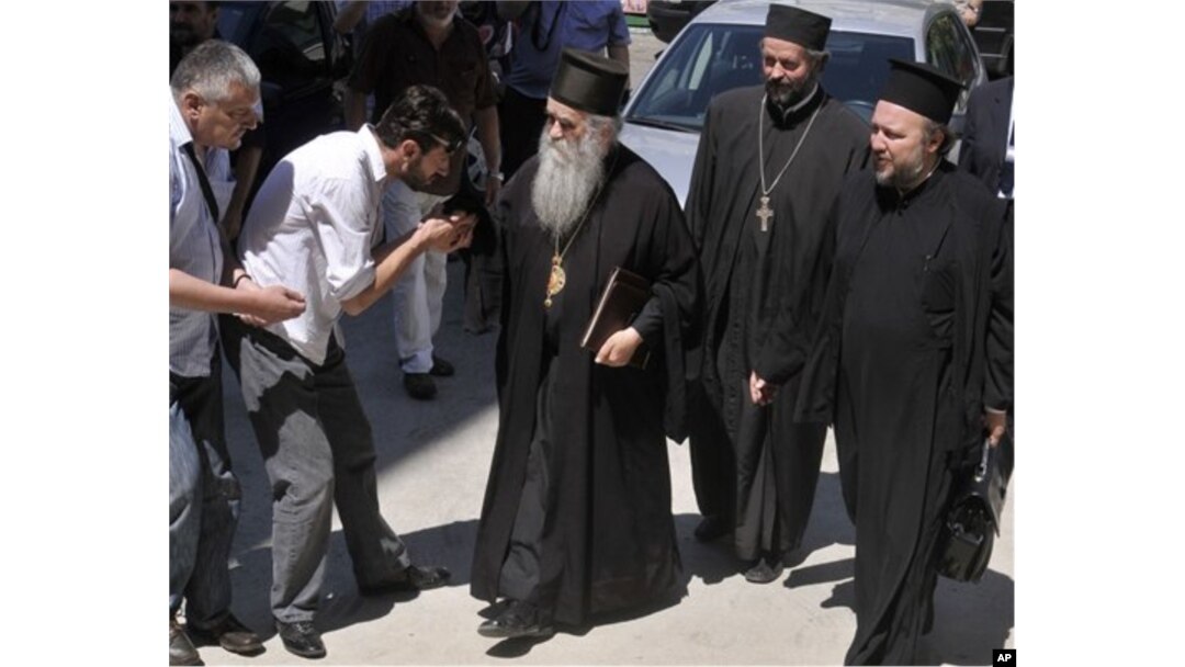 Amfilohije Radović, u sredini, stiže u zgradu suda u Podgorici u junu 2011. godine (Foto: AP)