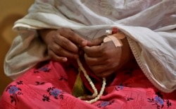 Nazima Shaikh, ibu dari Arbaz Mullah memegang tasbih, di Belagavi, India, 6 Oktober 2021. Arbaz Mullah adalah seorang pria Muslim yang jatuh cinta dengan seorang wanita Hindu. (Foto: AP/Aijaz Rahi)