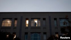 FILE - A worker looks out a window inside Pakistan's embassy in Washington, Nov. 5, 2007.