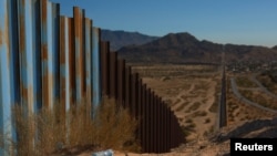 A plastic bottle lies in the sand near the border wall on the US-Mexico border, as seen from Ciudad Juarez, Mexico Oct. 23, 2024.