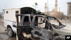A burned police vehicle left in the main street of Fallujah after clashes between Iraqi security forces and al-Qaeda fighters in Fallujah, 40 miles (65 kilometers) west of Baghdad, Jan. 5, 2014