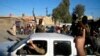 Al-Qaida fighters celebrate on vehicles taken from Iraqi security forces on a main street in Fallujah, west of Baghdad, Iraq, March 20, 2014.