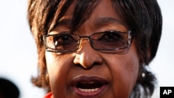 Winnie Madikizela-Mandela addresses the media in front of the house of her former husband and former South African President Nelson Mandela in Soweto, June 28, 2013.