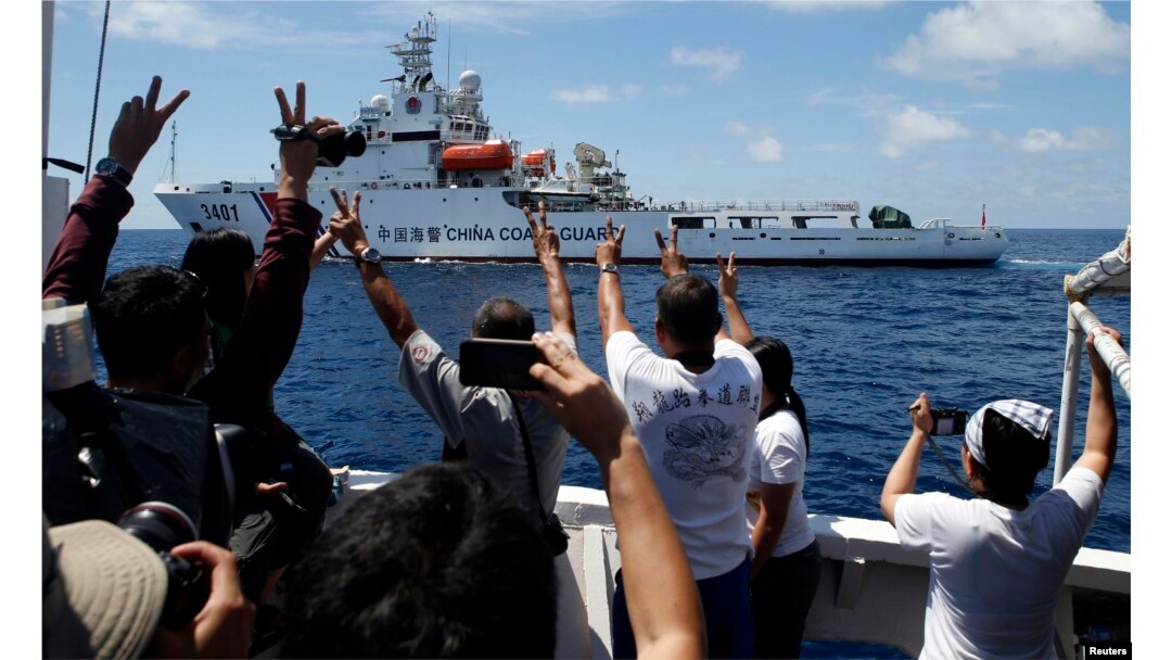 FILE - A Chinese Coast Guard vessel maneuvers to block a Philippine government supply ship with members of the media aboard at the disputed Second Thomas Shoal, part of the Spratly Islands, in the South China Sea.