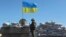FILE - A Ukrainian serviceman stands guard at a checkpoint near the town of Armyansk in Kherson region adjacent to Crimea, March 21, 2014.