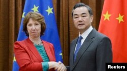 Kepala Urusan Kebijakan Luar Negeri Uni Eropa Catherine Ashton (kiri), berjabat tangan dengan Menteri Luar Negeri China Wang Yi, sebelum dimulainya pertemuan tingkat tinggi Eropa dengan para pemimpin baru China di Beijing (27/4).
