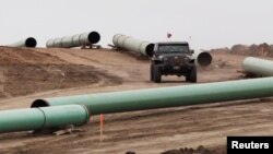 FILE - A vehicle drives next to a series of pipes at a Dakota Access construction site near the town of Cannon Ball, North Dakota, Oct. 30, 2016.