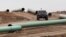 FILE - A vehicle drives next to a series of pipes at a Dakota Access construction site near the town of Cannon Ball, North Dakota, Oct. 30, 2016.