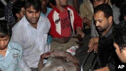 An injured man is helped at the scene of a building collapse in New Delhi, India, 15 Nov 2010