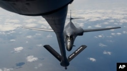 In this image provided by the U.S. Air Force, a B-1B Lancer assigned to the 9th Expeditionary Bomb Squadron, deployed to Andersen Air Force Base, Guam, receives fuel from a KC-135 Stratotanker over the Pacific Ocean, March 10, 2017. 