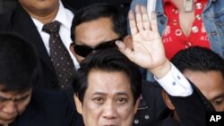 ຜູ້ນໍາເສື້ອແດງທີ່ໂດ່ງດັງ, ທ່ານ ອາຣິສມັນ ພົງເຣືອງຣອງ ໄດ້ໂບກມືໃສ່ປະຊາຊົນ ໃນຂະນະທີ່ທ່ານຍ່າງອອກ
ຈາກຫ້ອງການຂອງພະແນກສືບສວນສອບສວນ ພິເສດເພື່ອຈະໄປຫາຫ້ອງການຂອງທະນາຍຄວາມໃຫຍ່ ຢູ່ໃນ ນະຄອນຫລວງບາງກອກ, ປະເທດໄທ, ໃນວັນທີ 7 ທັນວາ, 2011.