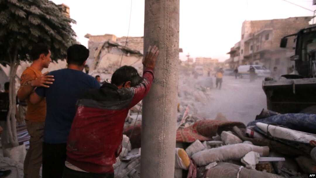 People react following a reported airstrike by Syrian regime forces in the town of Maaret al-Numan in Syria's northwestern Idlib province, Aug. 28, 2019. 