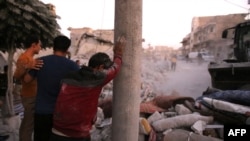 People react following a reported airstrike by Syrian regime forces in the town of Maaret al-Numan in Syria's northwestern Idlib province, Aug. 28, 2019. 