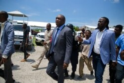 Opposition senators Youri Latortue, center, walks with Antonio Cheramy, right, towards the parliament building before a vote to ratify Prime Minister designate Fritz William Michel, in Port-au-Prince, Haiti, Sept. 11, 2019.