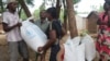 Beneficiaries of emergency food assistance in Malawi's Chikwawa district take home bags of maize provided by the United Nations' World Food Program on Oct. 2, 2024. (Lameck Masina/VOA)