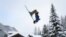 Teenager Luc makes a backflip on skis in the small resort of Zinal, Swiss Alps on January 9, 2018, after the access road which was cut by heavy snowfall reopened.