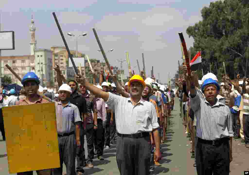 Supporters of Egypt&#39;s Islamist President Mohammed Morsi march in formation with sticks and protective gear outside of the Rabia el-Adawiya mosque near the presidential palace, July 2, 2013. 