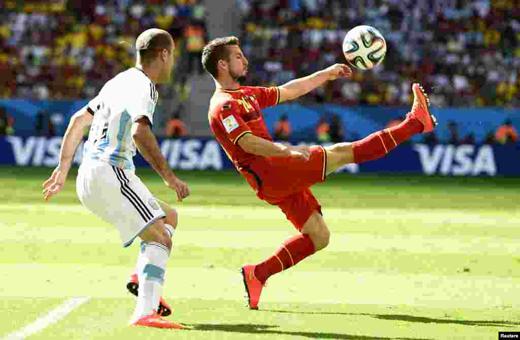 Belgium's Dries Mertens kicks the ball as Argentina's Rodrigo Palacio looks on at the Brasilia national stadium in Brasilia, July 5, 2014.