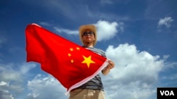 一位中国警察在在南中国海的西沙群岛上展示国旗（2014年9月14日）