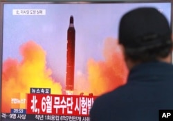 FILE - A man watches a TV news program, Oct. 16, 2016, showing a file image of a missile launch conducted by North Korea. The letters read "North attempted to fire a midrange Musudan missile in June."