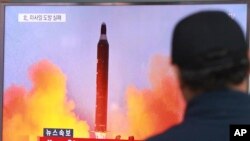  FILE - A man watches a TV news program, Oct. 16, 2016, showing a file image of a missile launch conducted by North Korea.