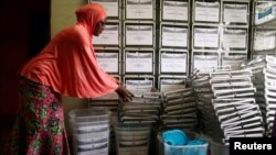 An administration municipal worker prepares ballot boxes before distributing them to the polling station for Sunday's presidential election in Yaounde, Cameroon Oct. 5, 2018. 