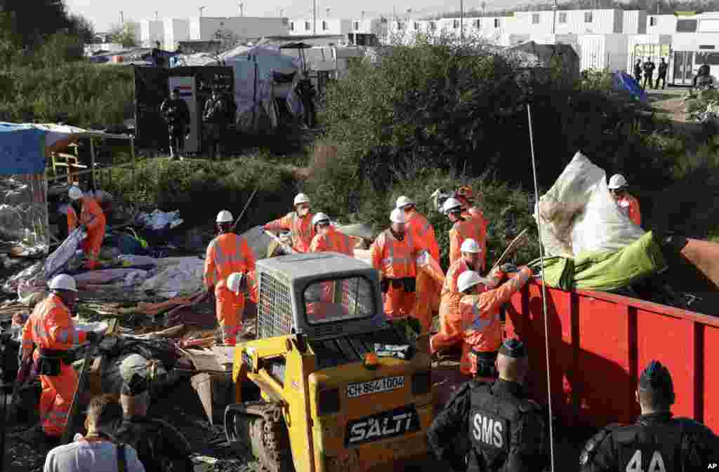 Crews demolish shelters in the makeshift migrant camp known as "the jungle" near Calais, northern France, Oct. 25, 2016. Crews have started dismantling the squalid migrant camp in France after the process to clear the camp began in earnest Monday.