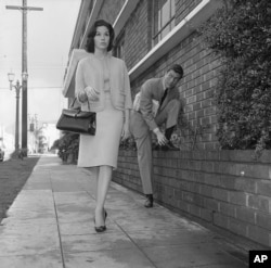 Actor Dick Van Dyke, right, looks on as actress Mary Tyler Moore walks by, Feb. 22, 1962, Los Angeles, California.