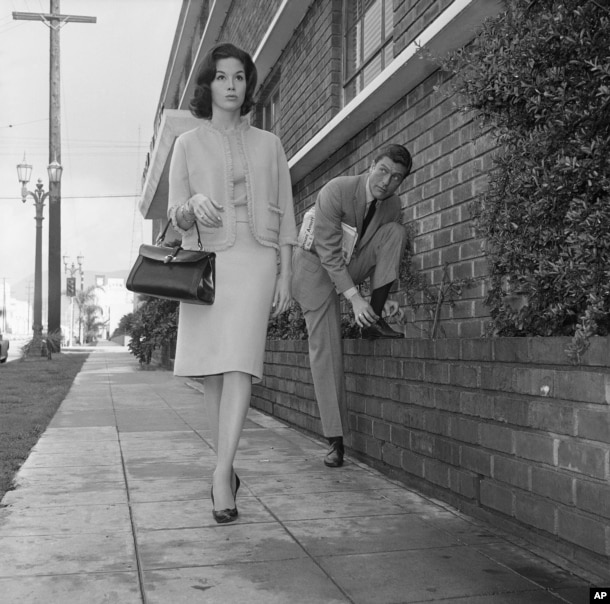 Actor Dick Van Dyke, right, looks on as actress Mary Tyler Moore walks by, Feb. 22, 1962, Los Angeles, California.